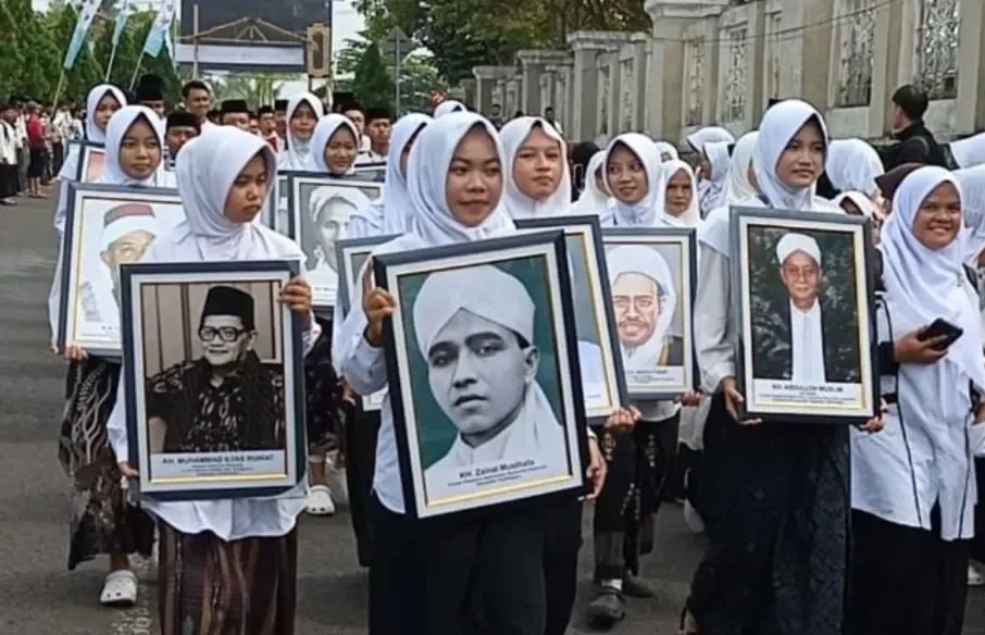 Sejumlah santri membawa potret ulama sesepuh dalam rangka memperingati Hari Santri Nasional 2026 dengan berjalan kaki di kawasan komplek perkantoran Pemerintah Kabupaten (Pemkab) Tasikmalaya, Jawa Barat, Selasa (20/10). (Foto: ANTARA/Feri Purnama)